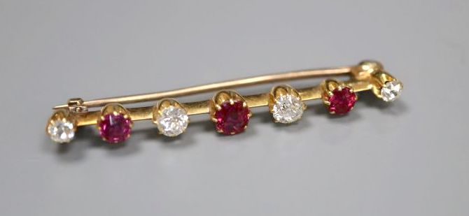 A yellow metal, four stone diamond and three stone ruby set bar brooch, 41mm, gross 3.6 grams.